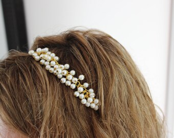 May include: A gold headband with a cascading design of white pearl beads.