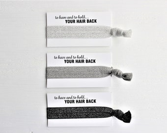 May include: Three hair ties with cards that say "to have and to hold... YOUR HAIR BACK". The hair ties are grey and black.