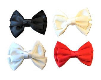 May include: Four satin bow ties in black, cream, white, and red. Each bow tie is neatly tied with a classic bow shape, suitable for formal events or adding a touch of elegance to any outfit.