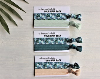 May include: Three sets of hair ties with a green and blue floral pattern. Each set includes two hair ties, one in a solid colour and one with the floral pattern. The cards have the text "to have and to hold... YOUR HAIR BACK".