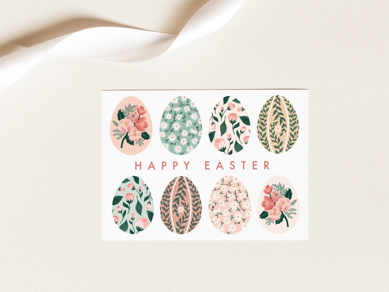 Puede incluir: Una tarjeta blanca con un dise&ntilde;o floral. La tarjeta presenta ocho huevos de color pastel con patrones florales. El texto "HAPPY EASTER" est&aacute; impreso en rojo en la tarjeta.