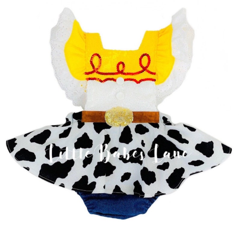 May include: A white and blue baby onesie with a yellow and red vest and a black and white cow print skirt. The vest has a red embroidered design and a brown belt with a gold buckle. The skirt is made of a soft, comfortable fabric and has a ruffled hem. The onesie is perfect for a baby girl who loves to play dress-up.
