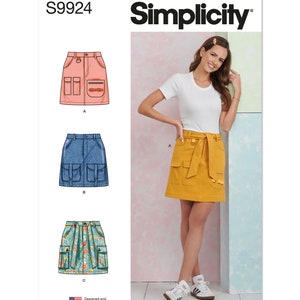 May include: Simplicity pattern S9924 features three skirt designs. The image shows a woman wearing a yellow skirt with pockets and a belt. The pattern includes a pink, denim, and floral print skirt option. The pattern is designed and printed in the USA.