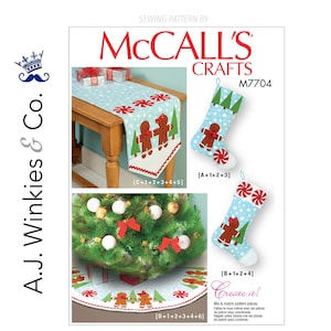 May include: McCall's Crafts sewing pattern M7704. The image shows a Christmas-themed design with a table runner, stockings, and a tree skirt. The designs feature gingerbread men, candy canes, and Christmas trees on a light blue background.