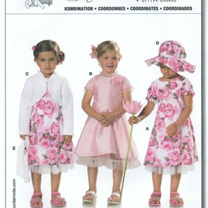 Peut inclure: Un patron de couture Burda pour enfants, avec des robes et accessoires. Le patron propose des robes à imprimé floral, un boléro et un chapeau de soleil. Le numéro du patron est 9648. Le texte sur le patron indique "TOUS LES PATRONS AVEC MARGE DE COUTURE ET OURLET."