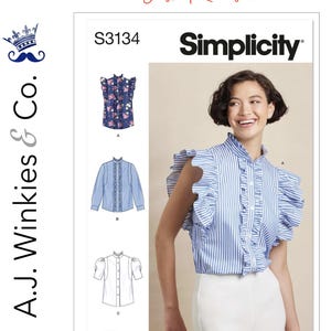 May include: Simplicity sewing pattern S3134 featuring a woman wearing a blue and white striped blouse with ruffles. The pattern includes illustrations of different blouse styles. The text "Just Released" is at the top.