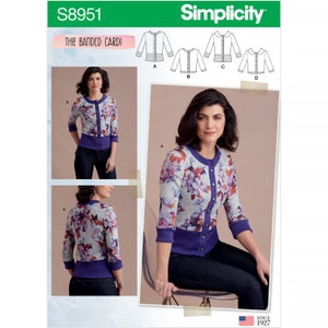 May include: A woman models a floral print cardigan with a purple trim and button closure. The image is a Simplicity sewing pattern, labeled "The Banded Cardi" with the number S8951. The cardigan has three-quarter sleeves.
