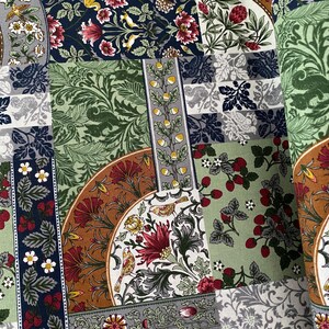 May include: A patchwork fabric with diverse floral and botanical designs. It features sections with red flowers, strawberries, and birds, set against green, navy, and grey backgrounds. The fabric has a vintage aesthetic, with a variety of patterns.