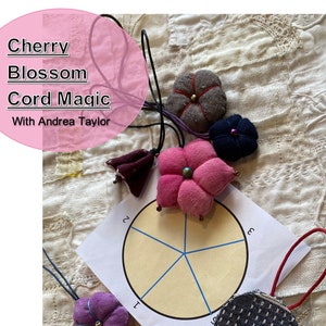 Può includere: L'immagine presenta diversi ornamenti floreali in tessuto fatti a mano in vari colori, tra cui rosa, marrone e blu navy. Ogni fiore ha una perla centrale ed è attaccato a un cordino. Il testo "Cherry Blossom Cord Magic" è visualizzato in un cerchio rosa.