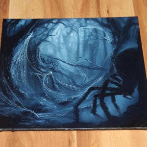 May include: A square canvas painting depicting a dark, monochromatic blue forest scene. A large, silhouetted spider is positioned on the right side, with intricate white spiderwebs stretching across the gnarled tree branches in the center.