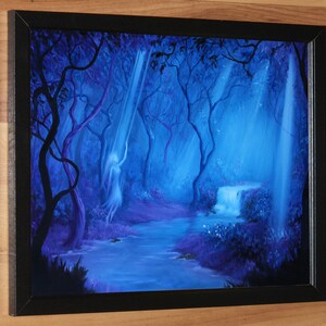 May include: Framed painting of a mystical forest scene. The artwork features a flowing river, a small waterfall, and ethereal figures bathed in blue and purple hues. The painting is set in a black frame.