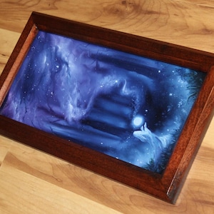 May include: A rectangular wooden frame containing a print of a dark blue, ethereal scene. The artwork depicts a glowing orb held by a figure amidst swirling blue mist and shadows, with a set of stairs leading into the deep, dark background.
