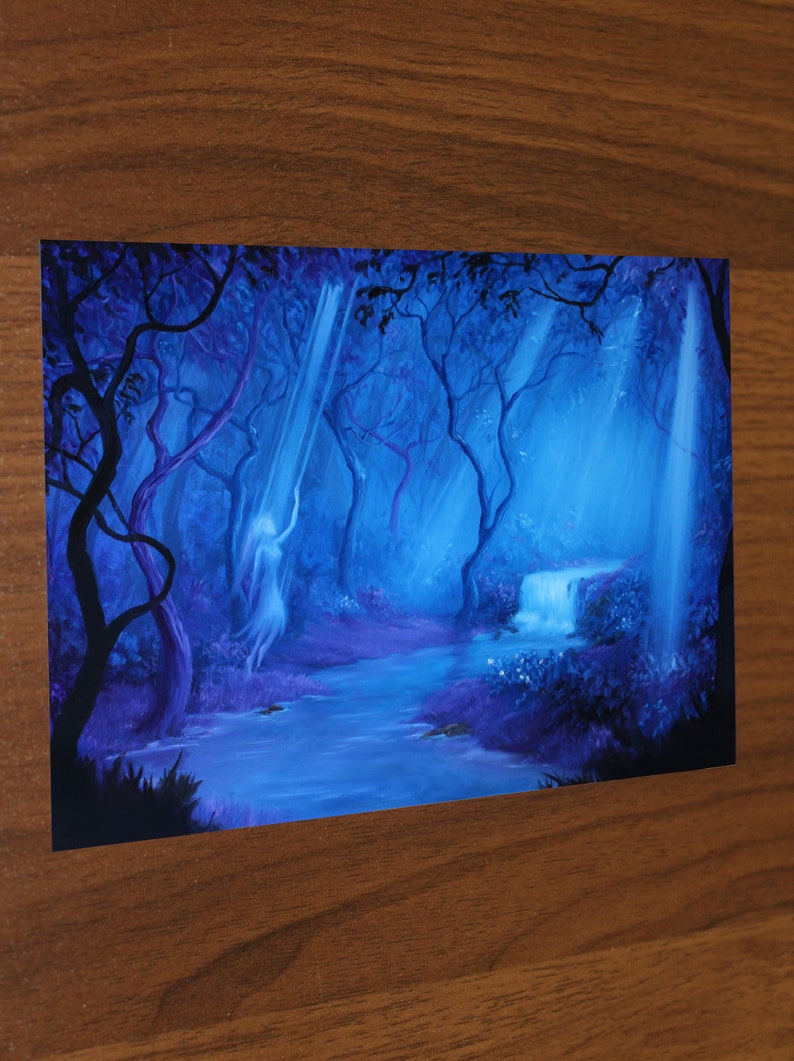 May include: A fantasy art print depicting a serene forest scene. The artwork features a flowing river, a small waterfall, and a figure bathed in ethereal light. The color palette is dominated by shades of blue and purple, creating a mystical atmosphere.