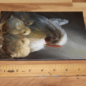 May include: An oil painting depicts a hen with three chicks in a nest. The hen has white and gray feathers, a red comb, and a yellow beak. The chicks are fluffy and yellow. The painting is on a rectangular canvas.