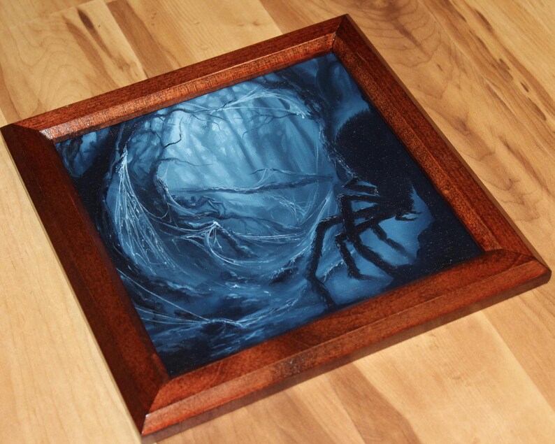 May include: A square wooden frame containing a dark blue and black painting of a forest scene with a large spider silhouette on the right side. The artwork features intricate web details and deep shadows, encased in a polished brown wood border.