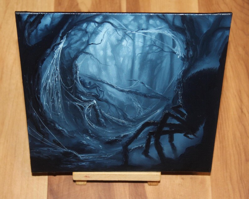 May include: A square canvas painting depicting a dark, monochromatic blue forest scene. The artwork features a large, silhouetted spider in the foreground with intricate, glowing white spiderwebs draped across twisted tree branches in the background.