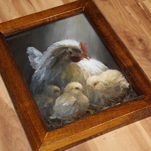 May include: A framed painting depicts a hen with three chicks. The hen is white and gray with a red comb. The chicks are yellow and fluffy. The frame is a dark brown wood.