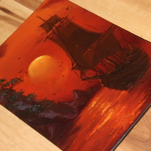 Pu&ograve; includere: Un dipinto a olio su tela che raffigura la sagoma scura di un veliero su un mare vibrante color arancione e rosso. Un grande sole giallo brillante &egrave; sospeso nel cielo sopra una costa rocciosa con alberi verde scuro, in toni caldi.