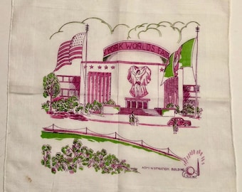 May include: White handkerchief with a pink and green illustration of the New York World's Fair Administration Building. The design includes flags, a statue, and the text "NEW YORK WORLD'S FAIR".