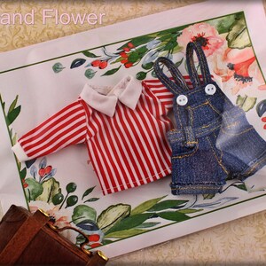 May include: Miniature doll clothing set featuring a red and white striped shirt with a white collar and cuffs, and denim overalls with white buttons. The set is displayed on a floral patterned background with the text "The Hand Flower".