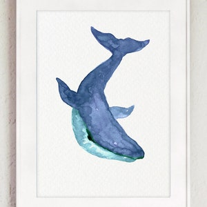 Puede incluir: Una pintura de acuarela de una ballena azul sobre un fondo blanco. La ballena est&aacute; mirando al espectador y tiene la boca abierta. La pintura est&aacute; enmarcada en un marco blanco.