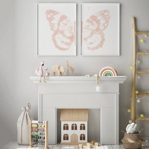 May include: A white fireplace mantel with a toy house, a wooden abacus, and a rainbow-colored wooden arch. Two pink flamingo figurines are perched on the mantel, and two butterfly prints hang above.
