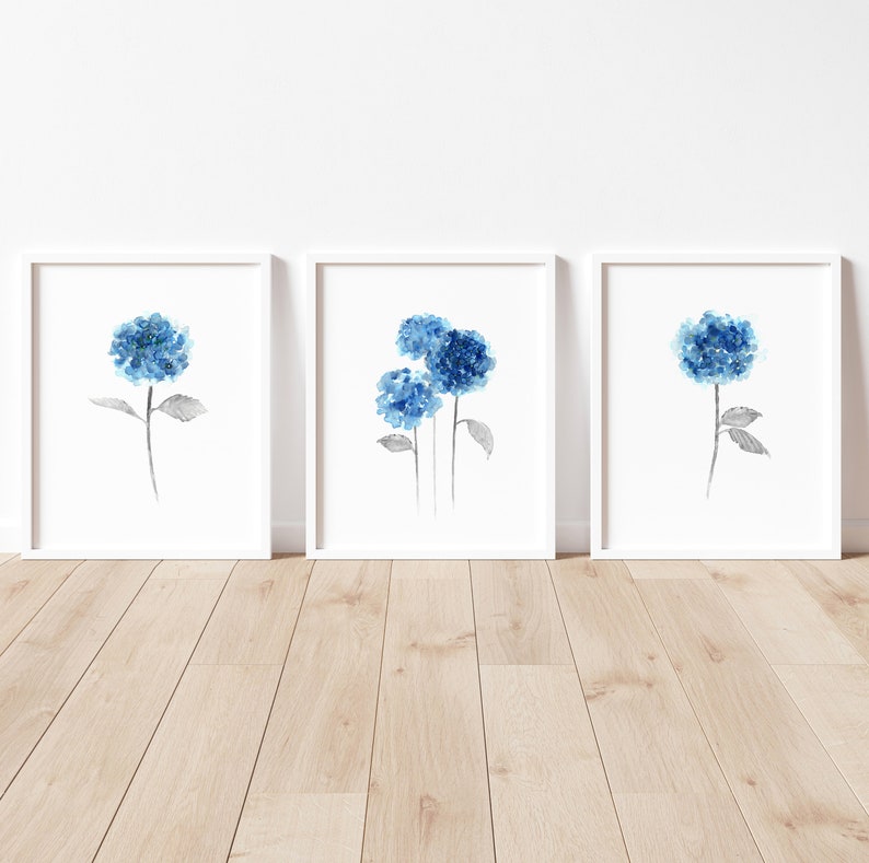 May include: Three framed watercolor paintings of blue hydrangeas on a white background. The hydrangeas are painted in shades of blue and gray.