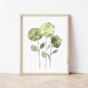 May include: A framed watercolor painting of three green hydrangeas with white centers. The flowers are on stems with green leaves against a white background.