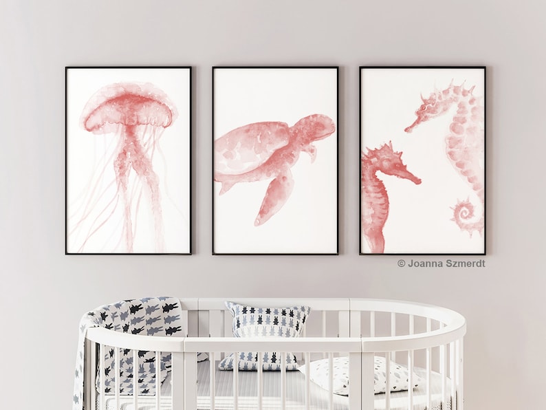 May include: Three framed watercolor prints of sea creatures in a coral pink color. The prints feature a jellyfish, a sea turtle, and two seahorses.