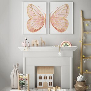 May include: A white fireplace mantel with a pink and gold butterfly print above it. There are pink flamingo figurines, a wooden dollhouse, and a rainbow-colored wooden arch on the mantel.