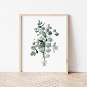 May include: A framed watercolor painting of a bouquet of eucalyptus leaves in shades of green and gray.
