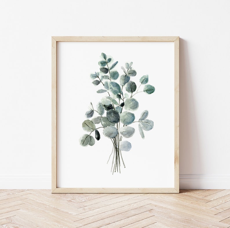 May include: A framed watercolor painting of a bouquet of eucalyptus leaves in shades of green and gray.