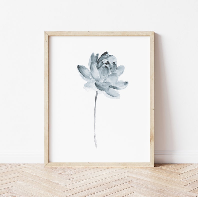 K&ouml;nnte beinhalten: Ein gerahmtes Aquarellbild einer einzelnen blauen Blume mit einem langen Stiel. Die Blume befindet sich in der Mitte des wei&szlig;en Hintergrunds.