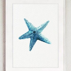 Puede incluir: Una pintura de acuarela de una estrella de mar azul sobre un fondo blanco. La estrella de mar est&aacute; en el centro de la imagen y est&aacute; mirando al espectador. La pintura est&aacute; enmarcada en un marco blanco.