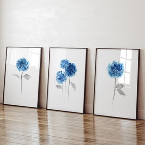 May include: Three framed watercolor paintings of blue hydrangeas with black stems and leaves on a white background.