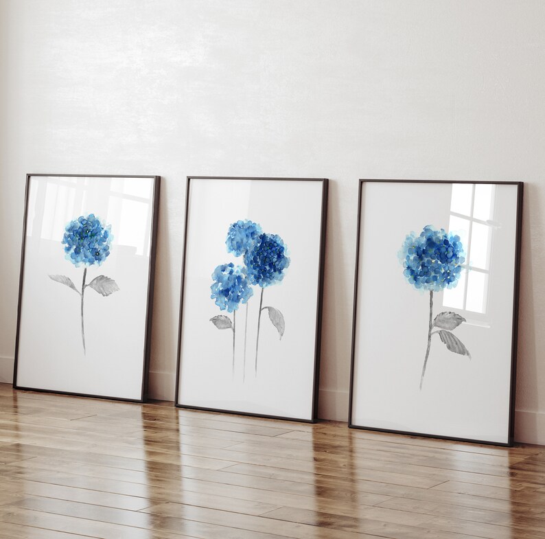 May include: Three framed watercolor paintings of blue hydrangeas with black stems and leaves on a white background.
