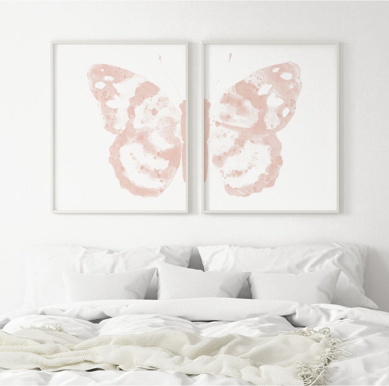 May include: Two framed prints of a pink watercolor butterfly, each print showing one wing of the butterfly.