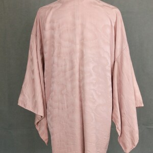 May include: A pale pink kimono with a cloud pattern. The kimono is made of a soft, silky fabric and has a relaxed fit.