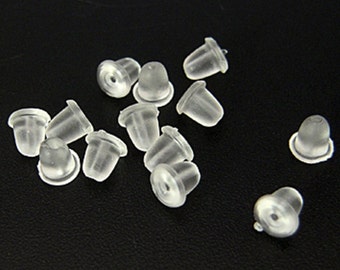 May include: A group of clear plastic earring backs. The backs are small and round, with a slight indentation in the center. They are designed to hold earrings in place.