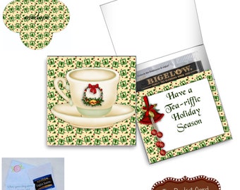 May include: A holiday-themed tea pocket card with a teacup illustration, a Bigelow tea bag, and the text "Have a Tea-riffic Holiday Season." The card is decorated with festive elements.