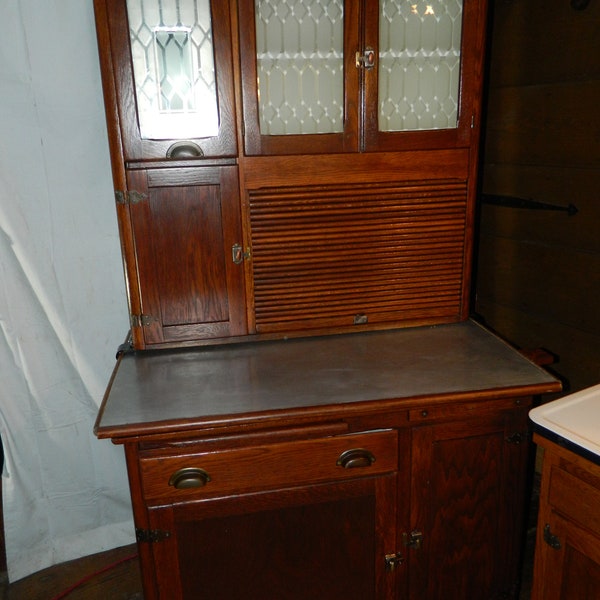 1915 Nappanee Hoosier Cabinet with etched glass,flour sifter , coffee,tea,and sugar jars ,2 cutting boards,and a pie safe and more.