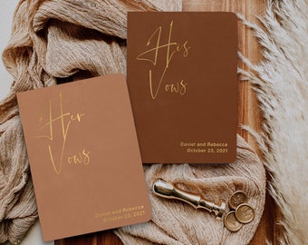 May include: Two brown paper covered journals with gold lettering. The top journal says "His Vows" and the bottom journal says "Her Vows". Both journals have the names "Daniel and Rebecca" and the date "October 23, 2021" printed on them.