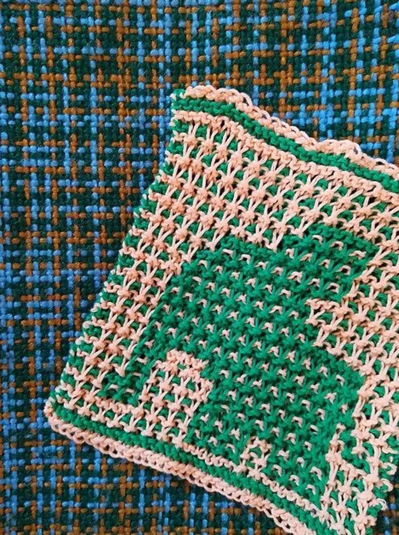 Puede incluir: Primer plano de un pa&ntilde;o de cocina tejido con un patr&oacute;n de cuadros verde y rosa. El pa&ntilde;o de cocina est&aacute; hecho con un punto sencillo y tiene una superficie ligeramente texturizada.