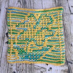 May include: A knitted dishcloth in yellow, green, blue, and white. The dishcloth has a geometric pattern.
