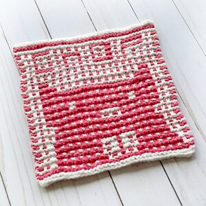 May include: A pink and white knitted dishcloth with a textured pattern.