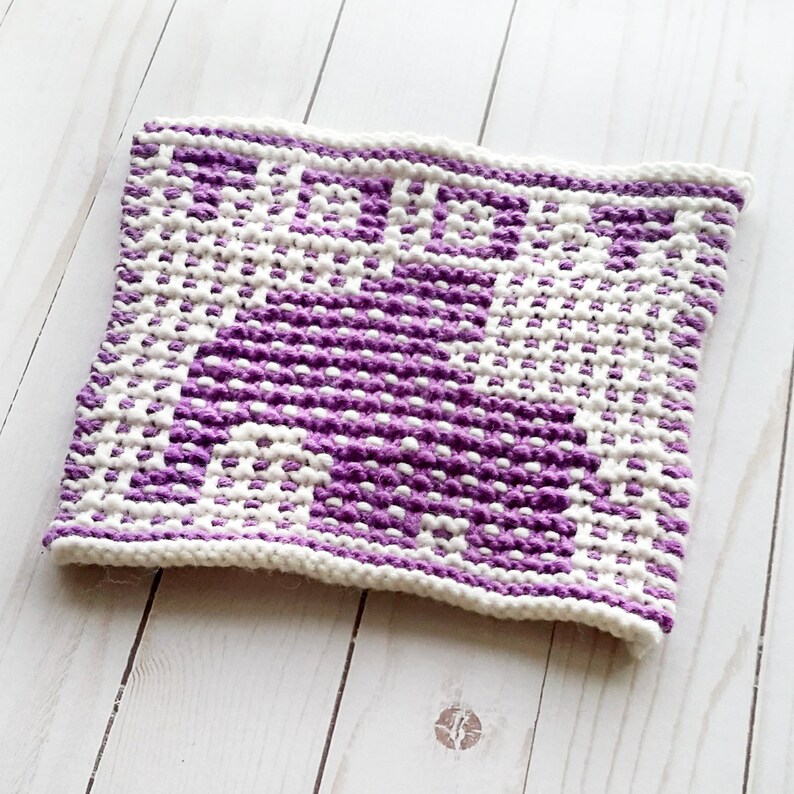 Puede incluir: Un pa&ntilde;o de cocina de punto morado y blanco con un patr&oacute;n geom&eacute;trico.