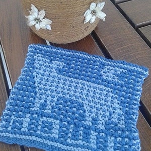 May include: A blue and white knitted dishcloth with a geometric pattern. The dishcloth is made of cotton and is ideal for drying dishes or cleaning surfaces.