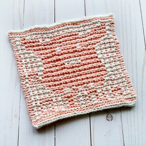K&ouml;nnte beinhalten: Ein gestrickter Geschirrtuch mit einem geometrischen Muster in Rosa und Wei&szlig;. Das Geschirrtuch ist aus weichem, saugf&auml;higem Garn gefertigt und eignet sich perfekt zum Abwaschen von Geschirr oder zum Trocknen der H&auml;nde.
