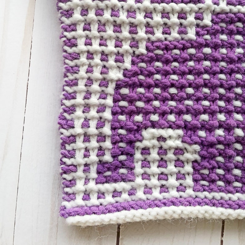 Puede incluir: Primer plano de una tela de punto con un patr&oacute;n morado y blanco. La tela est&aacute; hecha con un punto texturizado y tiene un aspecto peludo.