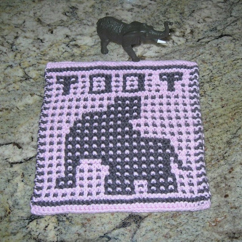 Puede incluir: Un pa&ntilde;o de cocina de punto rosa y gris con un dise&ntilde;o de elefante. El pa&ntilde;o de cocina tiene la palabra "TOOT" tejida en el borde superior.